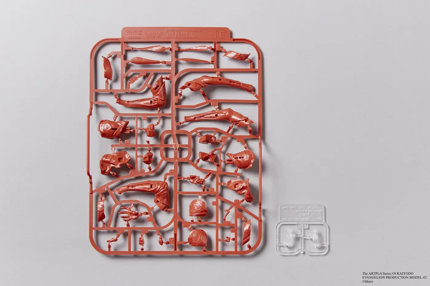 Red runner E with long model parts beside a small clear plastic runner