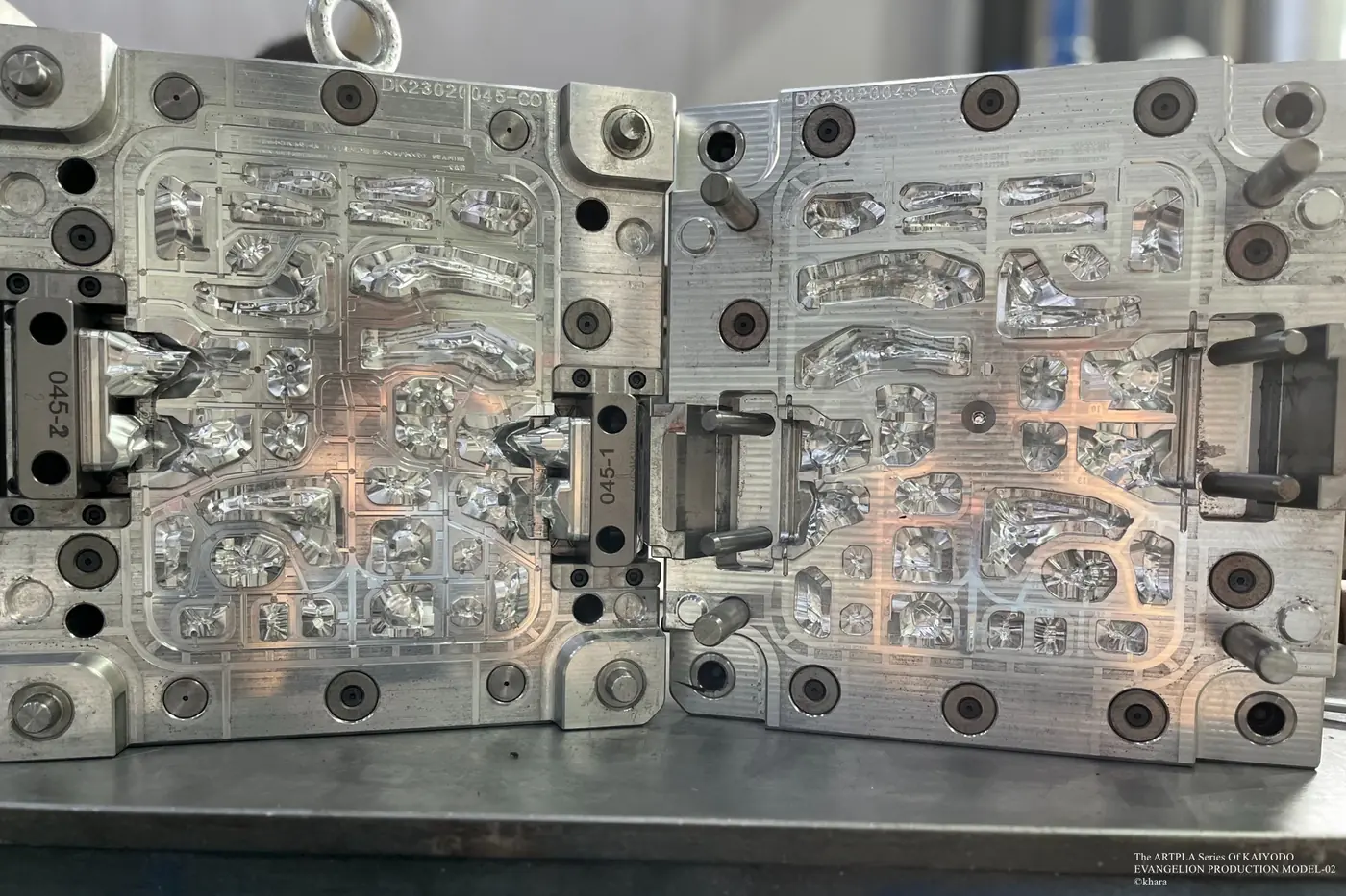 Open metal mold with elongated and compact cavities across both plates