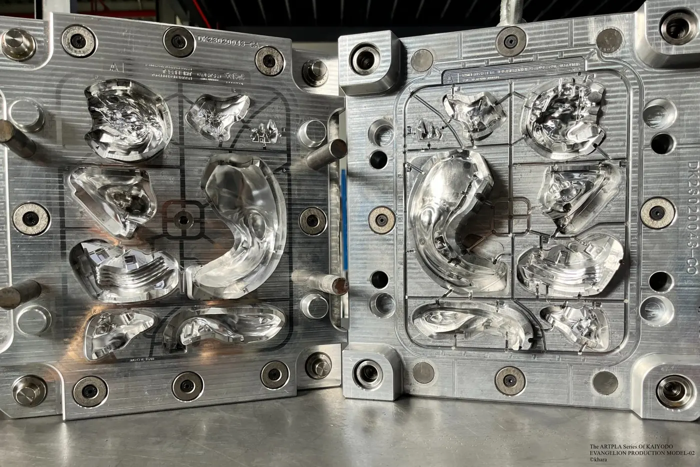 Open metal mold with large curved component cavities across two plates