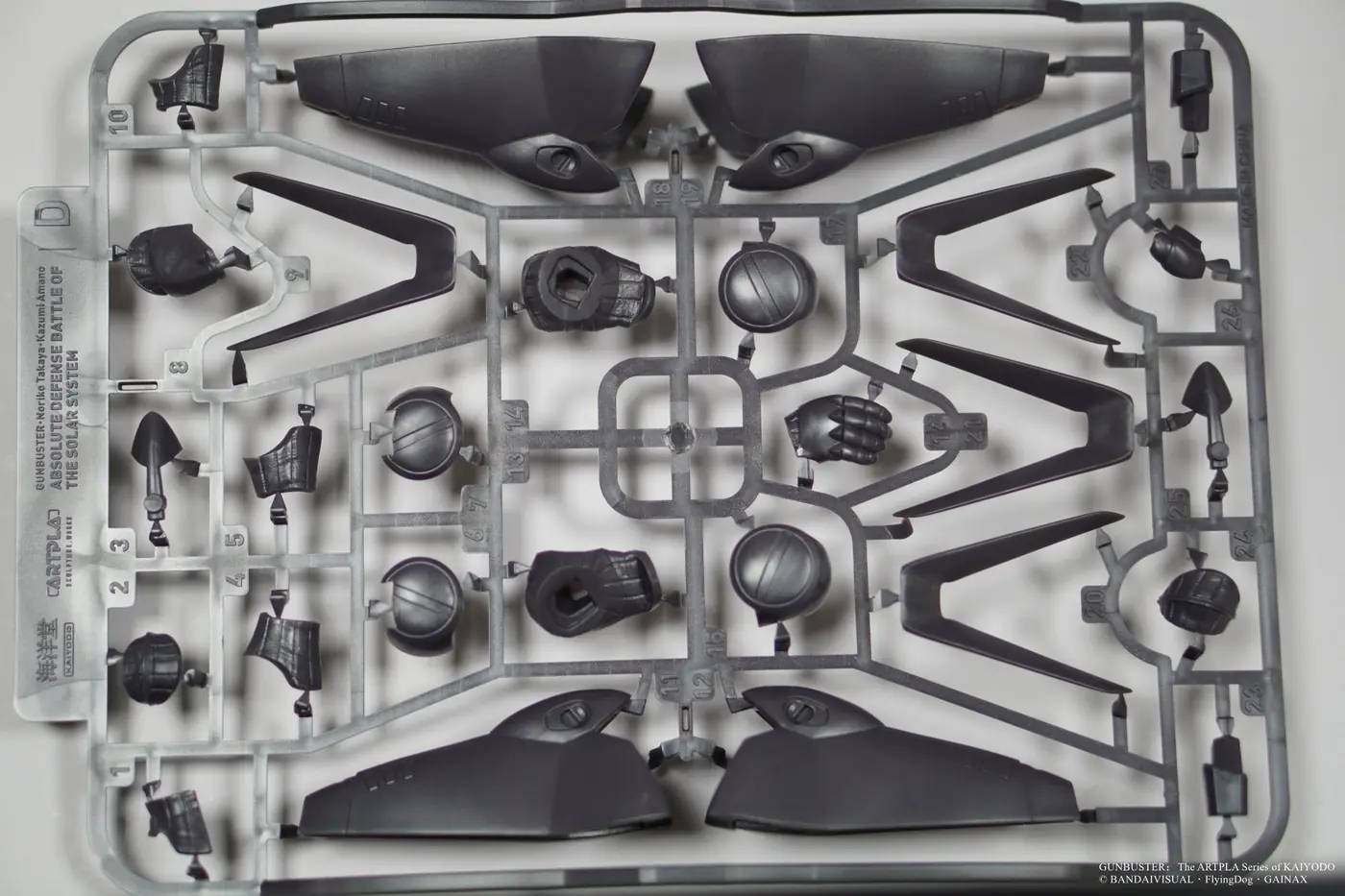 Dark gray plastic runner with large curved shells, round components and thin angular parts