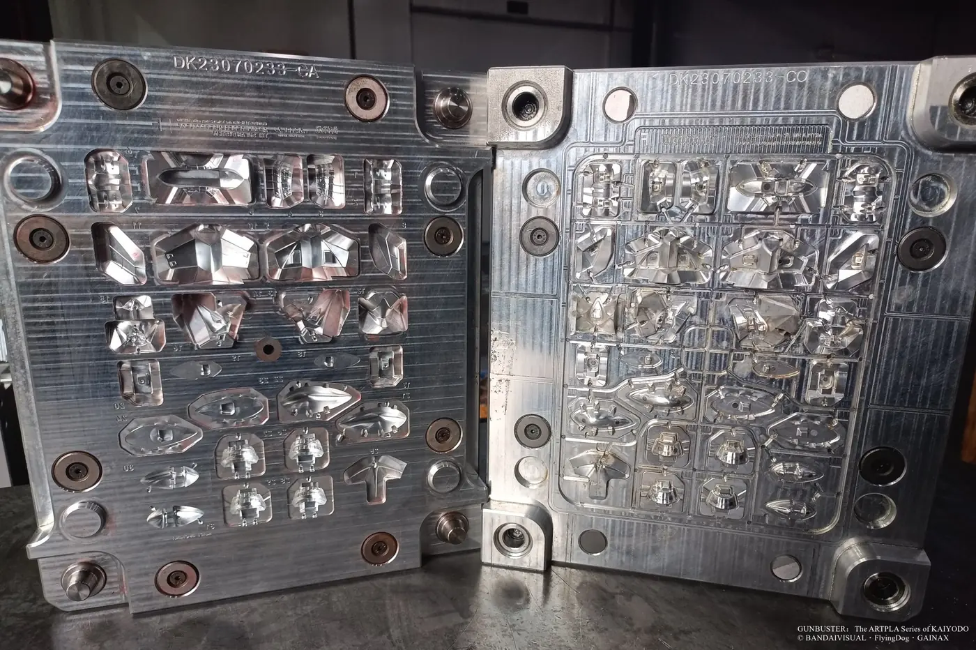 Open metal mold with angular robot panels, circular details and smaller component cavities
