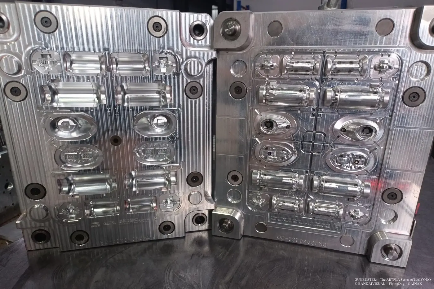 Open metal mold with paired cylindrical, oval and small component cavities