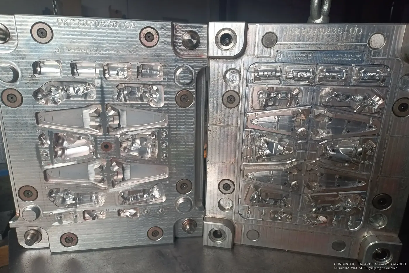 Open metal mold with elongated tapered panels, curved shells and smaller component cavities