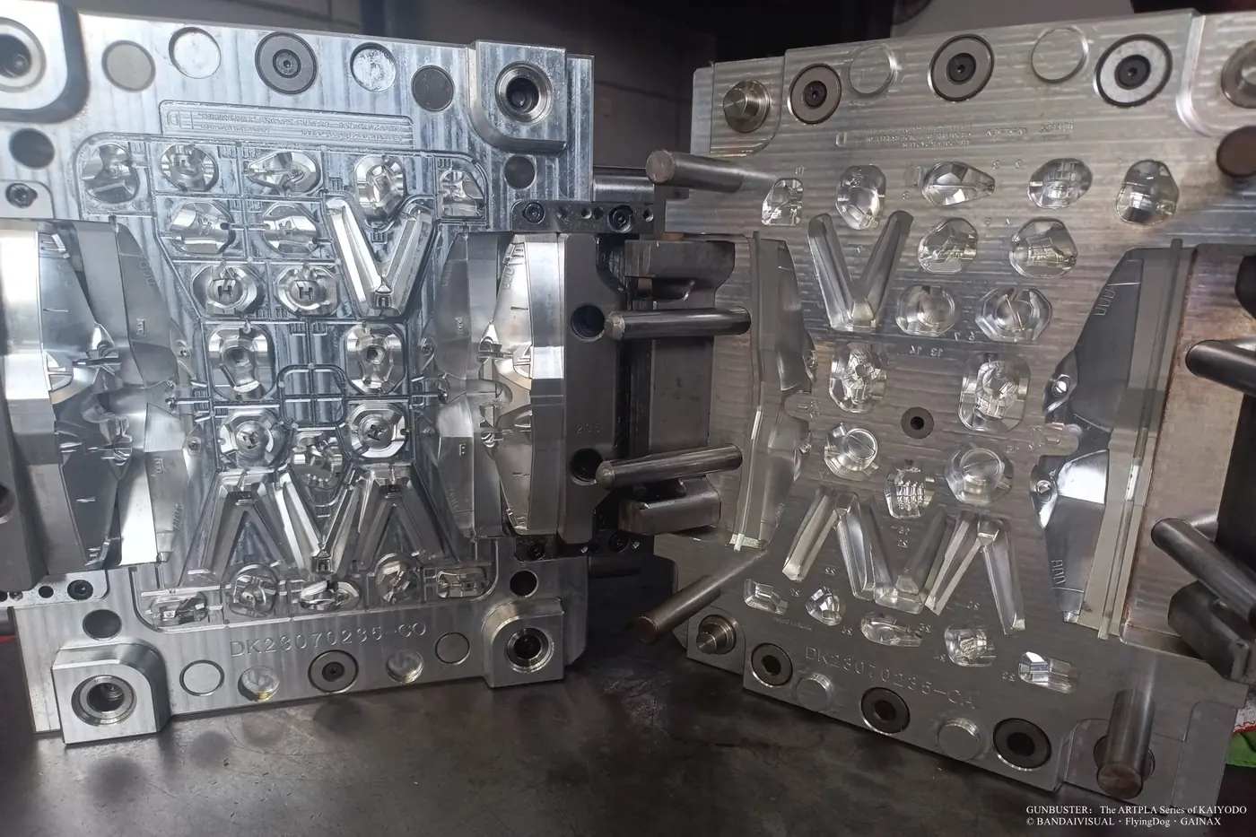 Open metal mold with long tapered panels, round details and smaller mechanical cavities