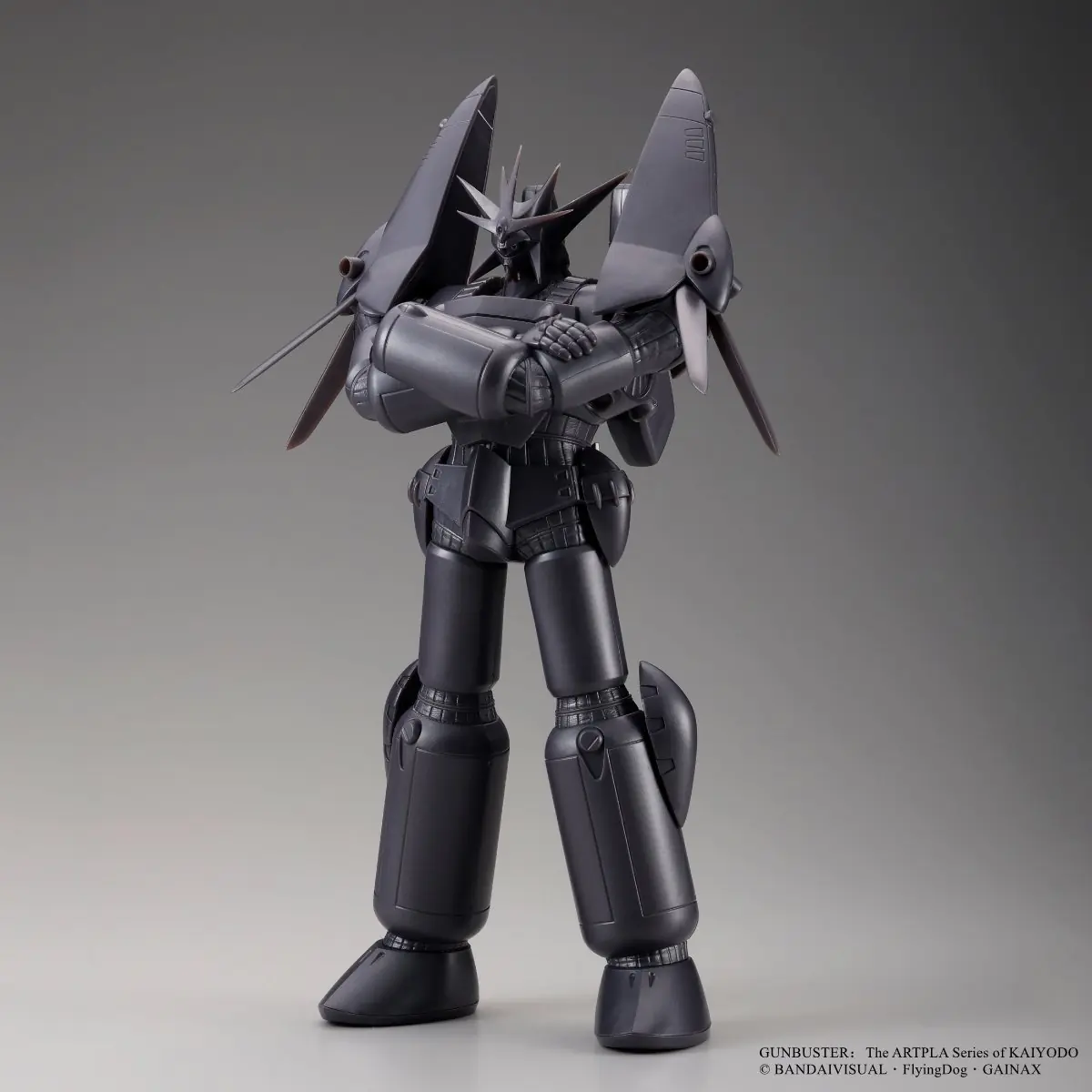 Dark gunmetal Gunbuster model standing with arms crossed in a front three-quarter studio view