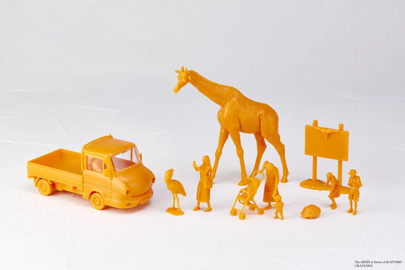 Single-color orange giraffe, truck, people, small animals and sign arranged on white