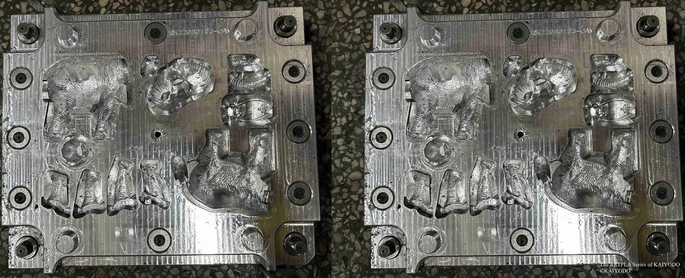 Two metal tooling plates with large animal-shaped and human-shaped cavities